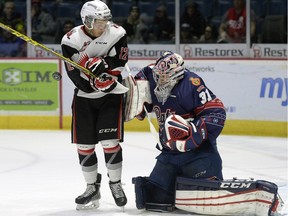 Regina Pats goalie Tyler Brown, right, is screened by Moose Jaw Warriors foward Jayden Halbgewachs during a WHL game at the Brandt Centre on Saturday.