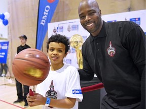 Eight-year-old Kian Tyson, left, meets former Toronto Raptors point guard Alvin Williams on Friday at the Regina downtown YMCA during a visit by the NBA All-Star Tour.