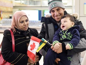 Safaa Saleh Khamees, left, and Radi Hayal Al Bardan holding their eight-month-old son Rida Radi Al Bardan after arriving from a Toronto flight at the Regina International Airport on Dec. 21, 2015.