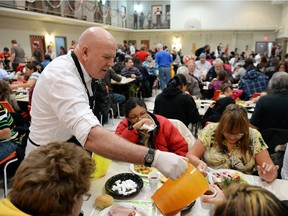 Henri Levesque, a volunteer with Souls Harbour RESCUE Mission serves drinks during the Rescue Missions annual Christmas dinner in Regina on Dec 23, 2014.