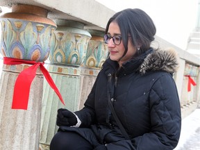 Nickita Longman shown on the Albert Street Bridge with red ribbons to pay tribute and recognize missing and murdered indigenous women across Canada. It was done during the holidays to show those affected that during this time of year are still, and always, in the thoughts of people, December 29, 2015.