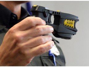 A Regina Police Service member holds a Taser, also known as a conducted energy weapon.