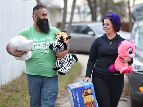 Hasan Hai, left, and Amanda McCall, two of the administrators of the Pay It Forward Regina Facebook page, load items into Hai's vehicle to give to Regina's needy.