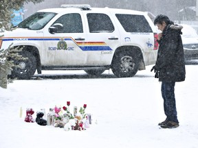 A resident of La Loche, Sask., pays his respects on Saturday to the victims of a Friday school shooting. The shooting left four people dead.