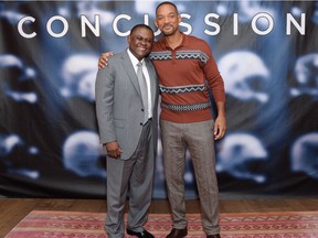 Dr. Bennet Omalu, left, and actor Will Smith pose together at the cast photo call for the film Concussion.