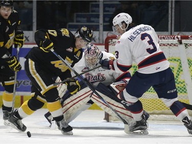 Brandon Wheat Kings forward John Quenneville (17) and Regina Pats defence James Hilsendager (3) battle for the puck in front of goalie Tyler Brown (31) during a game at the Brandt Centre in Regina, Sask. on Sunday January 24, 2016.