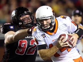 Ottawa Redblacks' Zack Evans (92) attempts to grab B.C. quarterback Travis Lulay (14) during CFL football action between the Ottawa Redblacks and B.C. Lions, in Ottawa on Friday September 5, 2014.