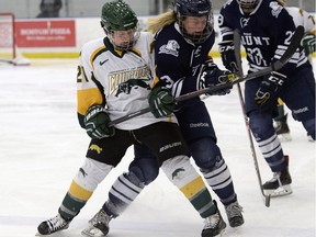 University of Regina Cougars forward Kylee Kupper, left, battles with Mount Royal Cougars forward Janessa Jenkins during Canada West hockey action at the Co-operators Centre on Saturday.