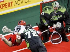 Curtis Dickson of the Calgary Roughnecks puts a shot on Saskatchewan Rush goalie Aaron Bold despite pressure from defender Adrian Sorichetti in Calgary on Saturday. The game was the season-opener for both teams.