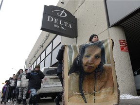 Delores Stevenson, right, leads a rally while holding a blanket with the face of her niece Nadine Machiskinic outside the Delta Hotel in Regina on Sunday Jan. 10, 2016. One year ago, Machiskinic fell 10 storeys down a laundry chute in the Delta Hotel, and died of her injuries.