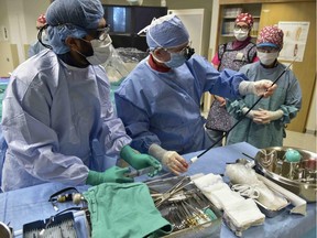 Dr. Mohammed Nayeemuddin (left), an interventional radiologist with the Regina Qu'Appelle Health Region, and vascular surgeon Dr. Don McCarville (centre) perform an aneurysm repair.