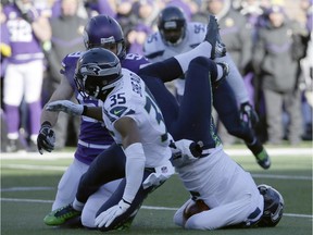 Seattle Seahawks punter Jon Ryan, 9, lands on his head after jumping over Minnesota Vikings linebacker Casey Matthews, 59, as he runs the ball in NFL playoff action Sunday.