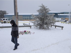 A boy leaves the memorial outside of La Loche Community School as RCMP continue to control the scene on Sunday, Jan. 24, 2016.