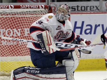 Regina Pats goalie looks up as the puck bounces up from a shot during a game against the Prince Albert Raiders at the Brandt Centre in Regina.