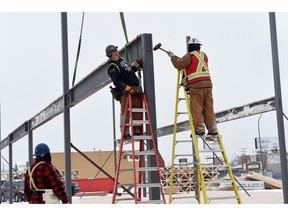 Ironworkers hammer a beam into place at the site of a new eye specialist building at Victoria Avenue and McAra Street in Regina.  A new report says non-residential construction activity will offset the slowdown in residential construction in the next decade.