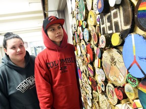 Sarah Crumly and Gilbert Sunshine-Crowe beside artwork from Building Our Home Fire, a project dedicated to raising awareness and sharing learning about the legacy of residential school system in hopes of rebuilding relationships between indigenous and non-indigenous peoples.