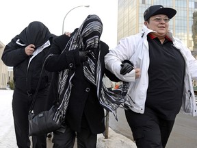 Kevin, left, and Tammy Goforth, middle, entering Court of Queen's Bench in Regina on Friday. The pair are accused of second-degree murder in the death of a four-year-old girl and causing bodily harm to the girl's two-year-old sister.