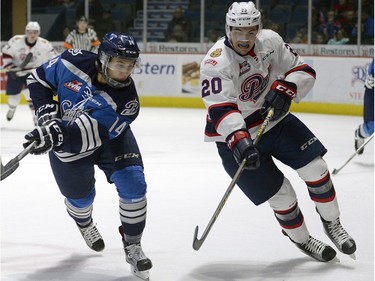 Pats' Luc Smith and Blades' Dustin Perillat  battle for the puck during WHL action between the Regina Pats and Saskatoon Blades in Regina.