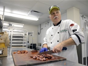 Rob Harrison, executive chef for the New Year's Day Levee, chops smoked duck for a pastry to be served at Government House in Regina, Sask. on Friday January 1, 2016.