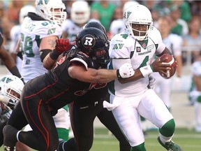 Zack Evans of the Ottawa Redblacks, left, shown sacking Saskatchewan Roughriders quarterback Darian Durant in a 2014 CFL game, has re-signed with Ottawa.