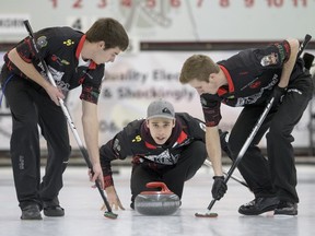 Garret Springer looks on as second Drew Springer, right, and lead Grady Lamontagne sweep a stone during Saturday's action at the Saskatchewan junior men's curling championship in Saskatoon.