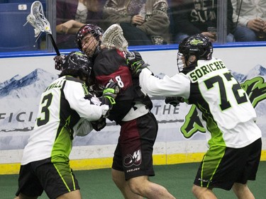 Saskatchewan Rush's Adrian Sorichetti and Jeff Cornwall smash up Colorado Mammoth's  Callum Crawford in Lacrosse action at SaskTel Center,  January 29, 2016.