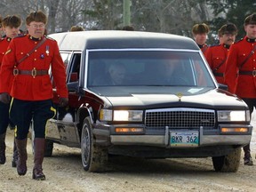 The hearse containing the casket of RCMP Constable Dennis Strongquill is escorted by some of the over 300 police officers who came to the church in Powerview, Man. for his memorial service on Thursday, Dec. 27, 2001.