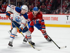 MONTREAL, QC - FEBRUARY 06:  Connor McDavid #97 of the Edmonton Oilers skates the puck against Jeff Petry #26 of the Montreal Canadiens during the NHL game at the Bell Centre on February 6, 2016 in Montreal, Quebec, Canada.  The Montreal Canadiens defeated the Edmonton Oilers 5-1.  (Photo by Minas Panagiotakis/Getty Images)