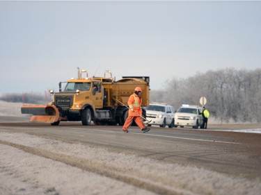 A highways worker walks at the site of a fatal accident involving a pick-up truck and a semi north of Balgonie on highway 10 on Thursday Feb. 25, 2016.