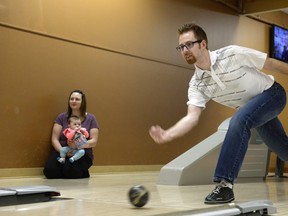 Brad Moens bowls while his fiancé Lisa Zver and daughter Addelyn look on at Golden Mile lanes.