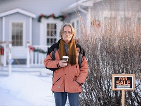 Rudi Bruer, thirty plus year resident and vice-president of the tenant association  of Copper Sands, stands by a for sale sign in front  of his home.