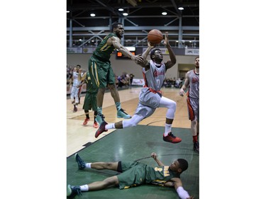 Cougars guard Jonathan Tull (6) is fouled by Wesmen guard Denzel Lynch-Blair (0) during a playoff game held at the University of Regina on Saturday Feb. 27, 2016.