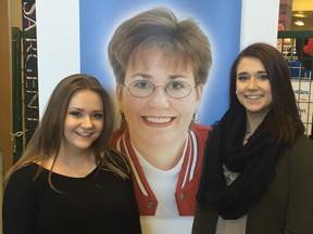 Jenna England, left, and her sister Sara pose with a picture of their mother, Sandra Schmirler, during the Sandra Schmirler Foundation telethon, held at the Scotties Tournament of Hearts on Feb. 21, 2016 in Grande Prairie, Alta.