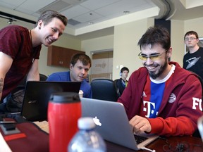 Jesse Millar, Mathew Wilkie, and Brayden Streibel, from left, gather around Streibel's screen during Global Game Jam held at the Petroleum Technology Research Centre in Regina on Sunday Jan. 31, 2016.