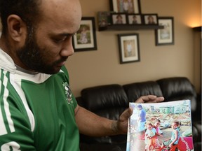 Peni Lutu holds a photo of his sister's destroyed Fijian house in Regina on Sunday Feb. 28, 2016. Lutu's Fijian hometown was recently destroyed by a cyclone. The local rugby player and coach will return to Fiji with fundraised money to help reconstruct.