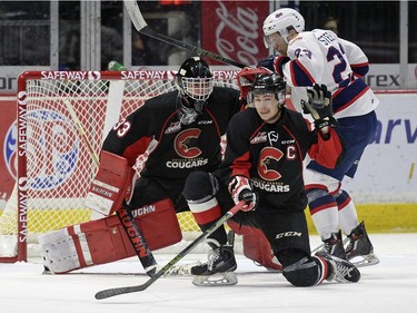 Prince George Cougars defenceman Sam Ruopp, 2, gloves a shot on goal while Regina Pats forward Sam Steel, 23, braces for impact during a WHL game held at the Brandt Centre on Saturday.