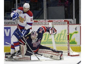 Regina Pats goalie Tyler Brown makes a save while Edmonton Oil Kings forward Brandon Baddock falls on top of him during a WHL game held at the Brandt Centre on Sunday.