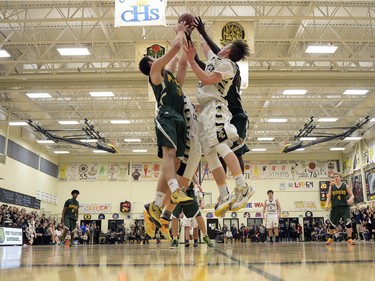 A group of players from the Luther Lions and the Winnipeg John Taylor Pipers jump for a rebound during the 64th annual LIT basketball tournament in Regina on Thursday.