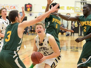 Michael Vanderhooft  of the Luther Lions goes against three defenders from the Winnipeg John Taylor Pipers during the 64th annual LIT basketball tournament in Regina on Thursday.