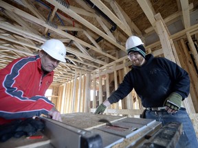 MLA Mark Docherty, left, and Ben Sipple, manager of family services for Habitat for Humanity, work on a project on the former site of Haultain School.