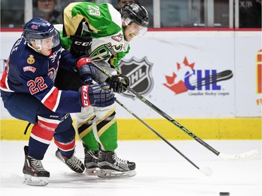 Regina Pats' Rykr Cole Pats and Prince Albert Raiders' Simon Stransky battle for the puck during WHL hockey action at the Brandt Centre in Regina on February 26, 2016.
