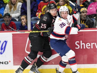 Red Deer Rebels' Adam Musil and Regina Pats' Cole Sanford battle on the boards during WHL hockey action at the Brandt Centre in Regina on February 29, 2016.