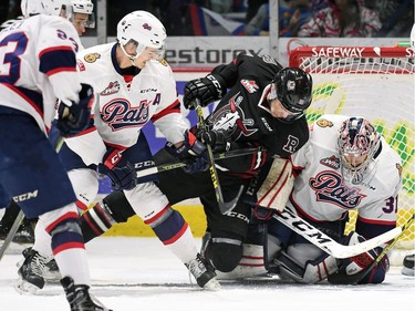 Regina Pats netminder Tyler Brown and teammate Sergey Zborovskiy and Adam Helewka with the Red Deer Rebels scramble for the puck during WHL hockey action at the Brandt Centre in Regina on February 29, 2016.