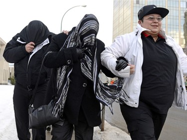 Kevin, left,  and Tammy Goforth, middle, are lead into the Court of Queens Bench in Regina.