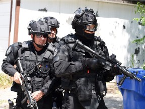 Regina police service SWAT members in the alley of the 1100 block of Robinson Street of Regina during a training exercise on June 10, 2015.