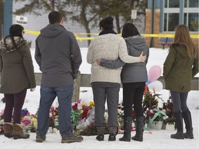 People at a roadside memorial in front of the La Loche Community School on Jan. 27. A teacher and an aide were killed there during a shooting incident.
