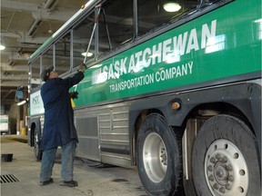 An STC employee cleans the windows on a bus at the STC garage in Regina.