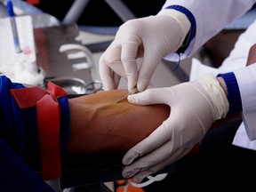 A worker takes blood from a blood donor.