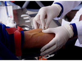 A nurse prepares a blood donor.