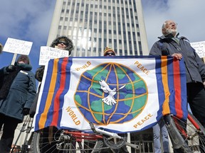 A group of protestors hold a flag during a peace rally held at City Hall in Regina on Saturday March 19, 2016. Various speakers addressed concerns about Canada's sale of weapons to Saudi Arabia and its involvement in the Syrian conflict. MICHAEL BELL